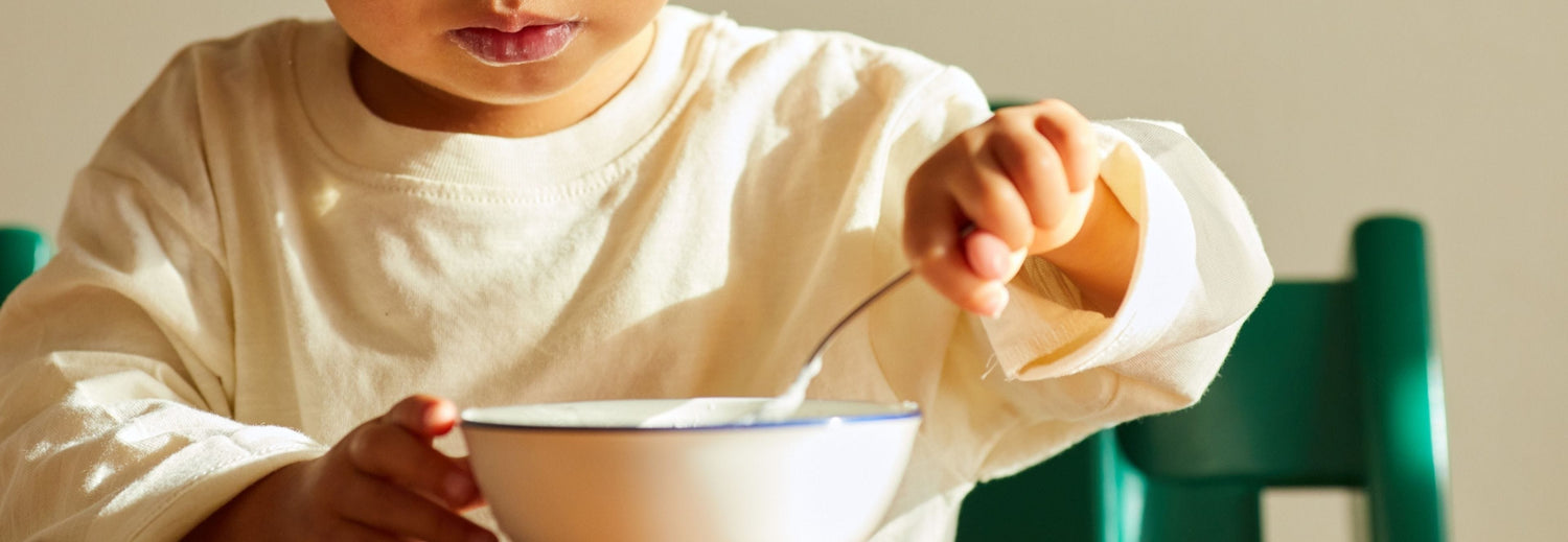 child eating a bowl of yogurt