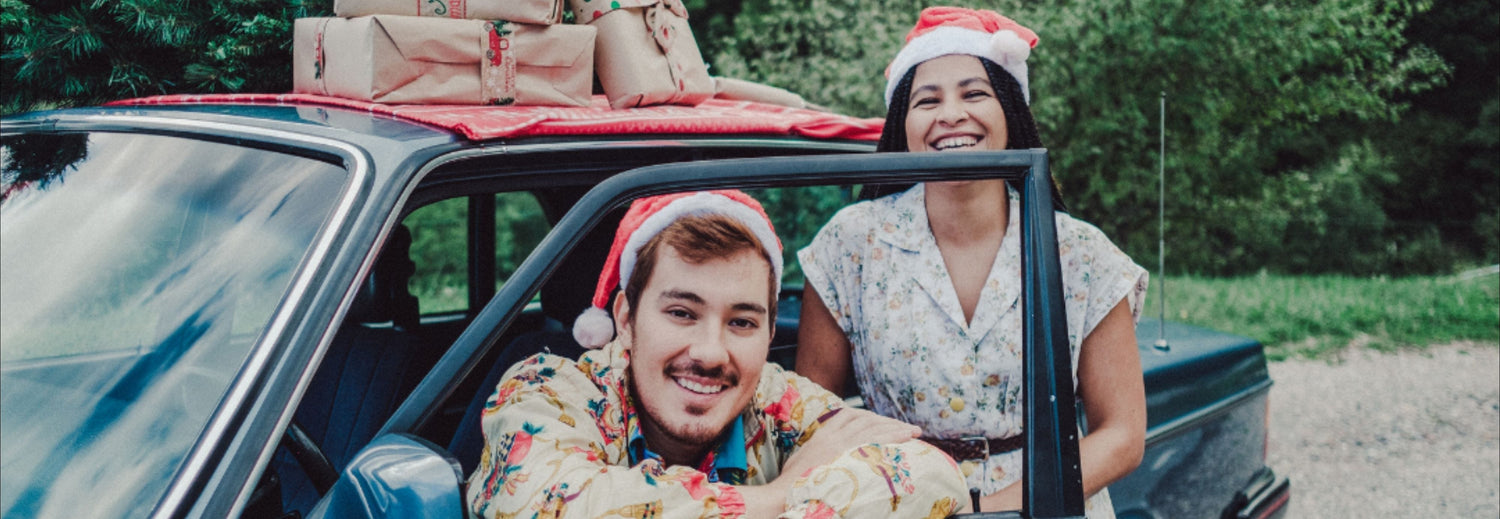 Friends wearing Santa hats and loading gifts into their car