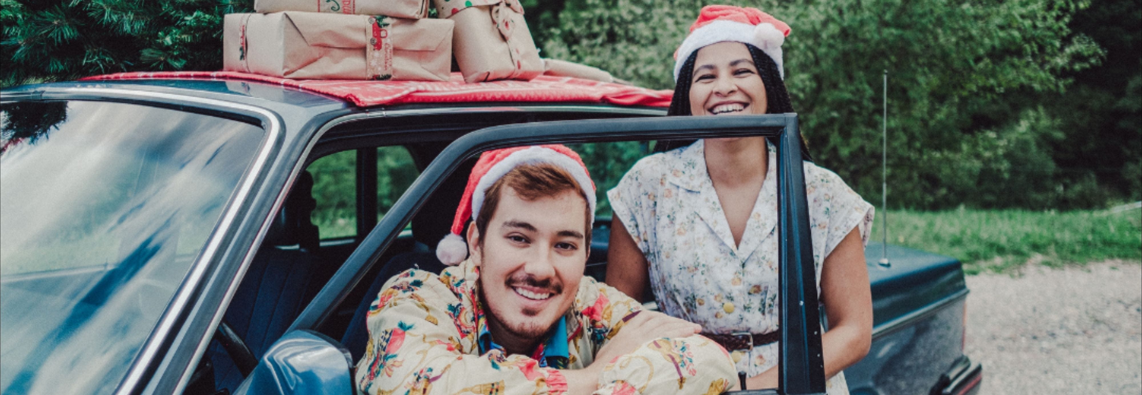 Friends wearing Santa hats and loading gifts into their car