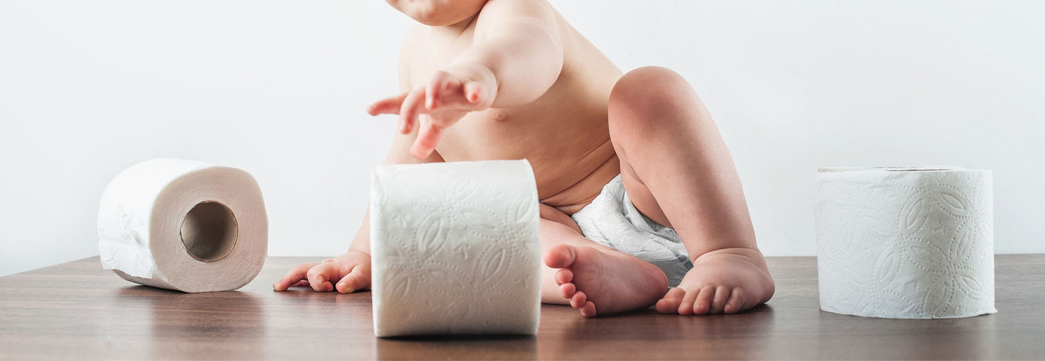 Toddler playing with rolls of toilet paper