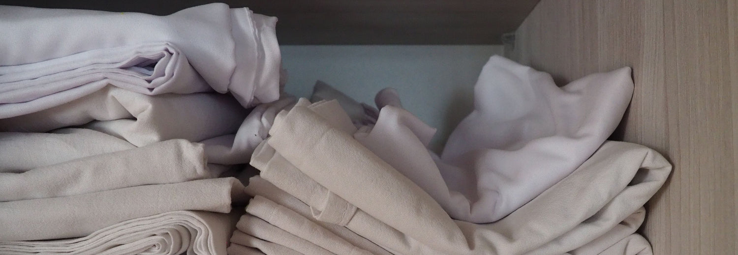 stack of folded old linens in a closet