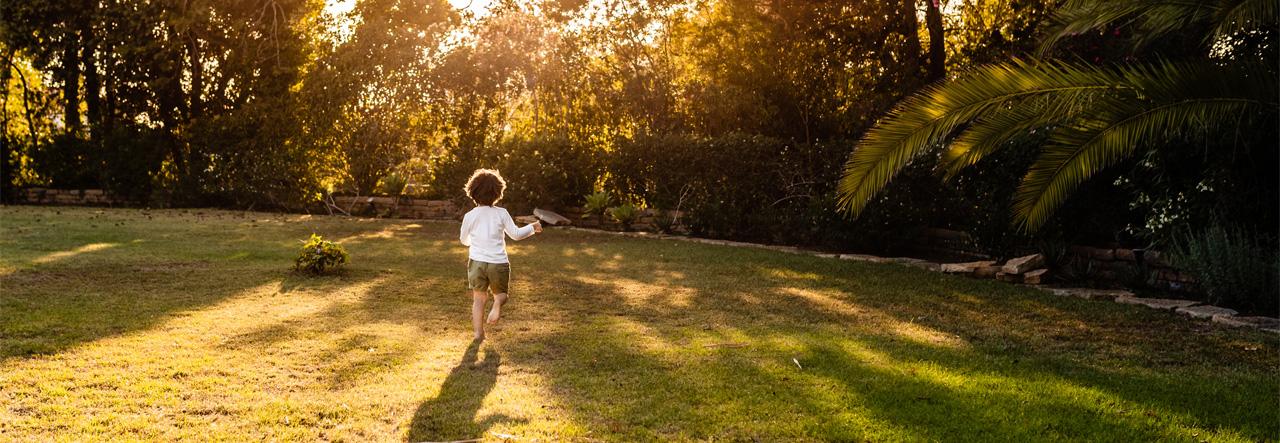 Child running barefoot in the grass