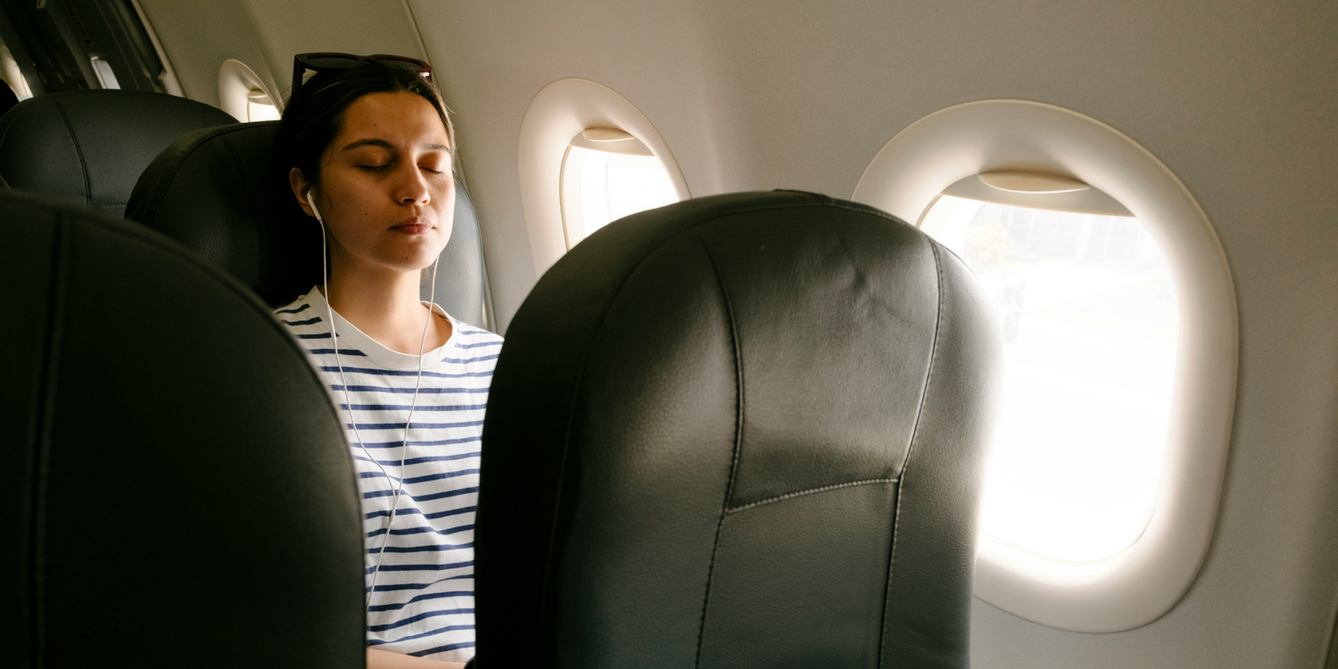 woman sleeping on sunny airplane