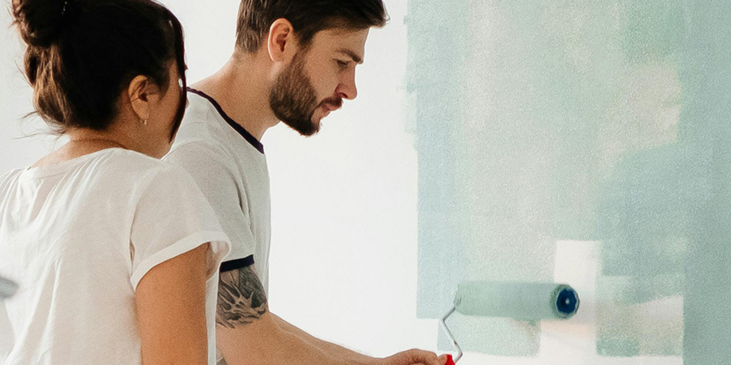 couple painting bedroom blue together