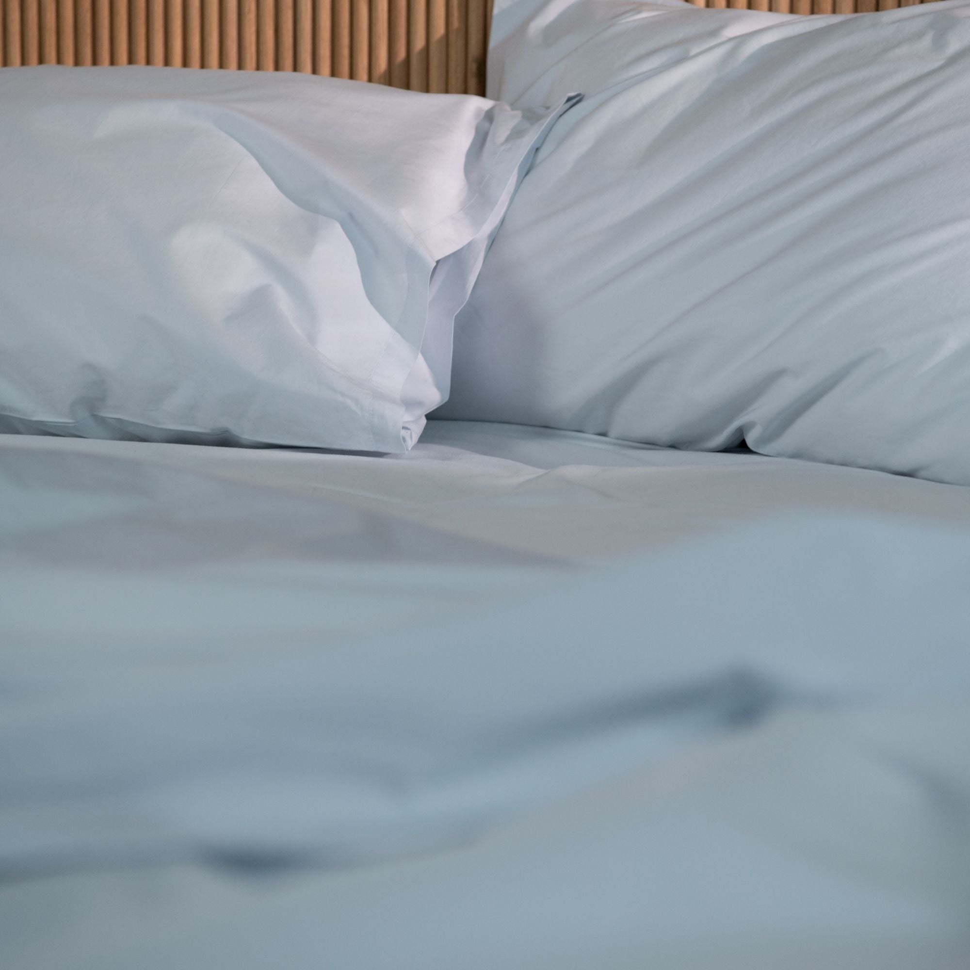 Light blue bedding set with pillows on a bed