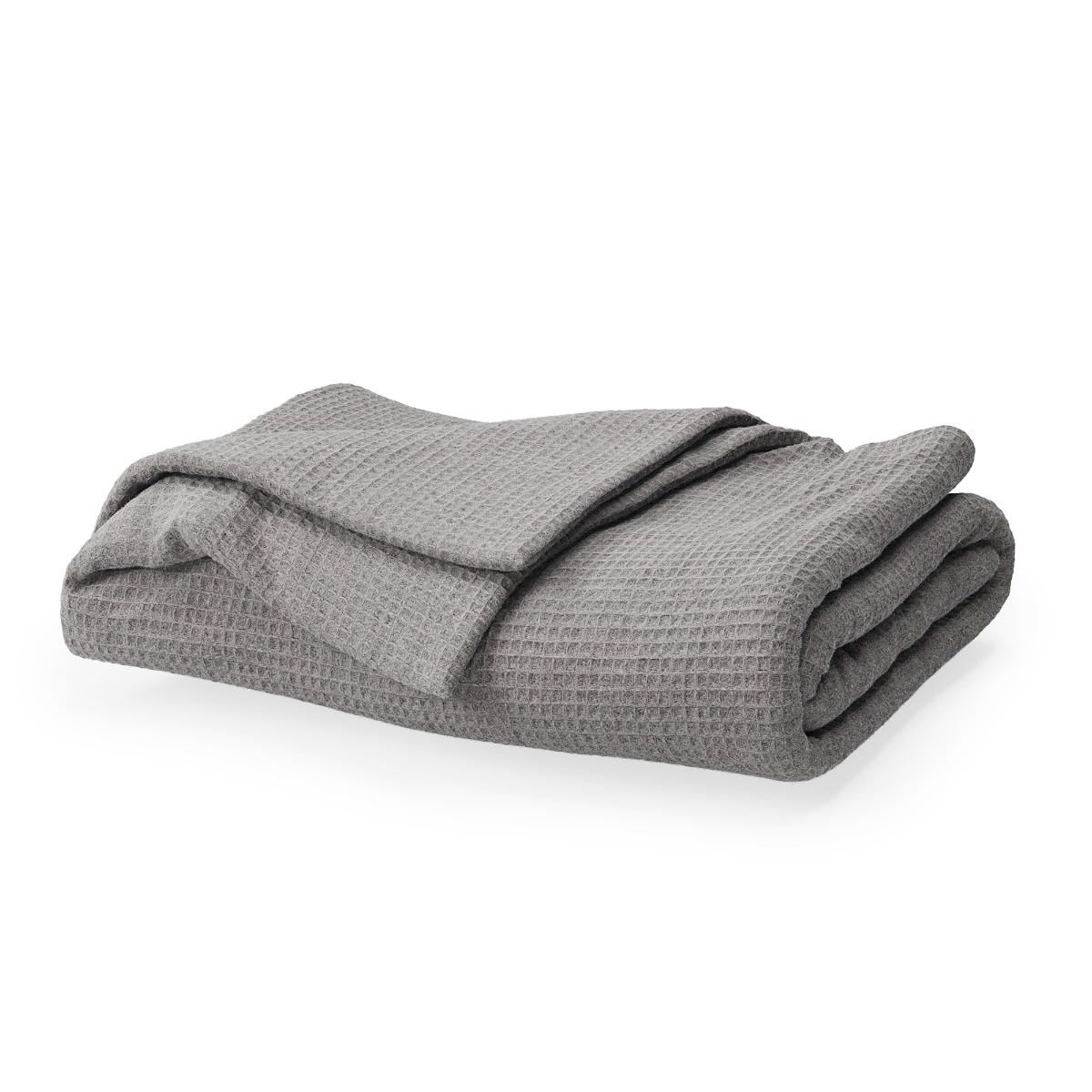 Folded gray textured blanket on a white background #color_pebble grey