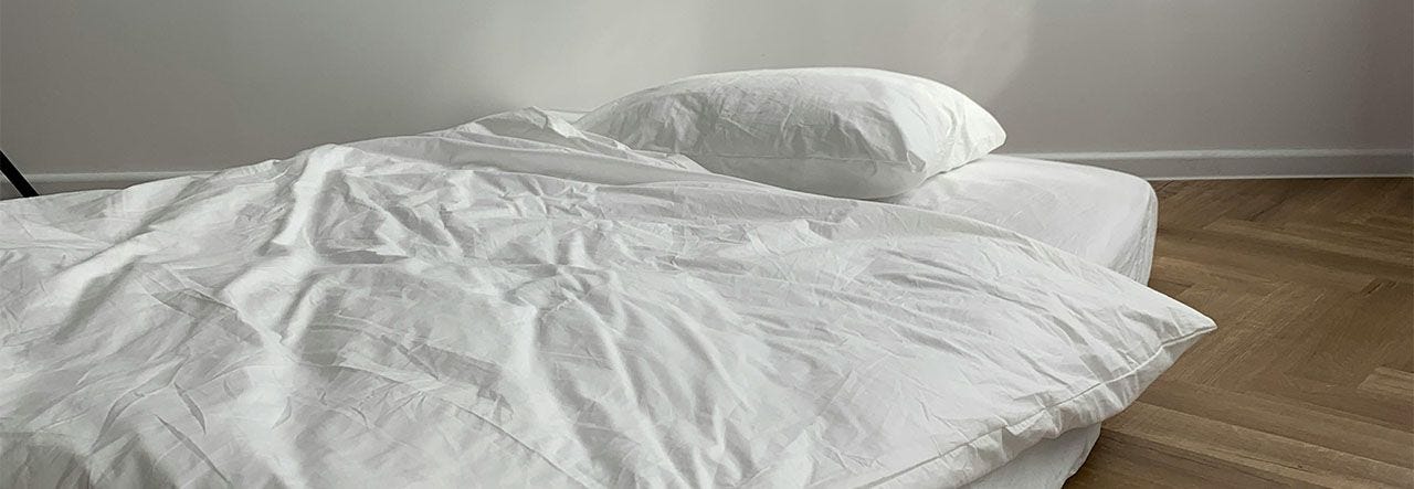 Mattress on the floor with white bedding