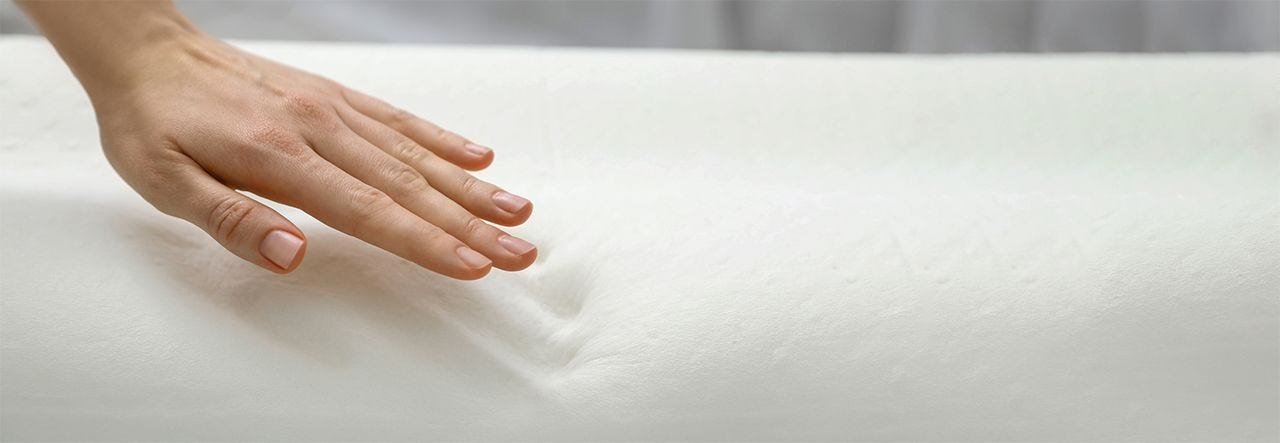 Woman's hand leaving an imprint on a soybean foam mattress