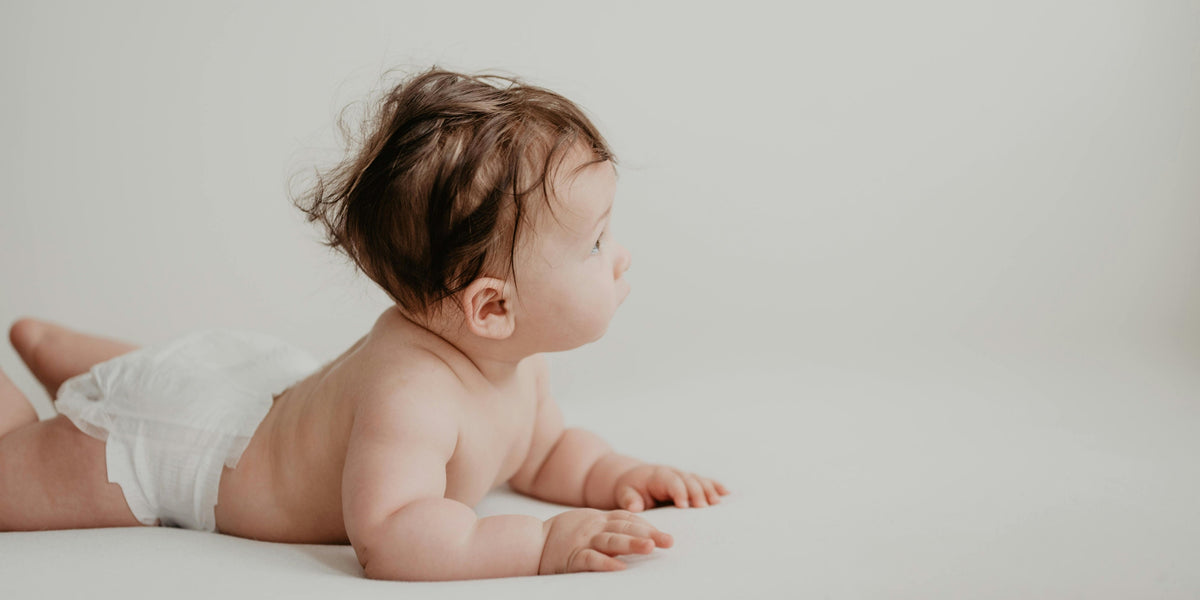 Healthy baby, dressed in just a diaper, crawling