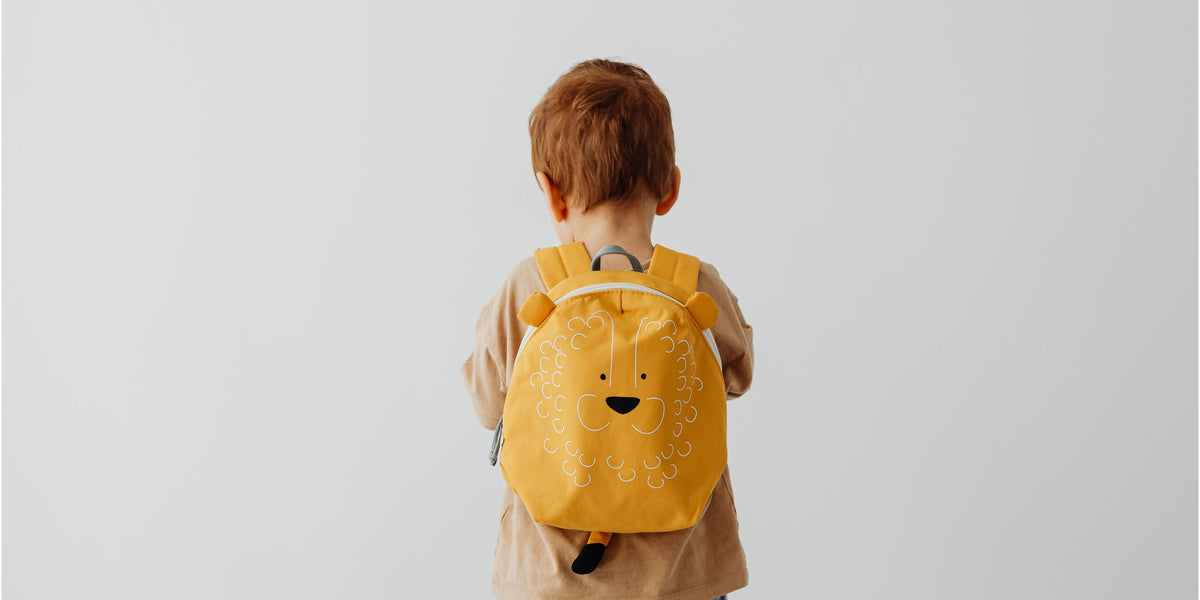 school aged boy with yellow backpack and red hair