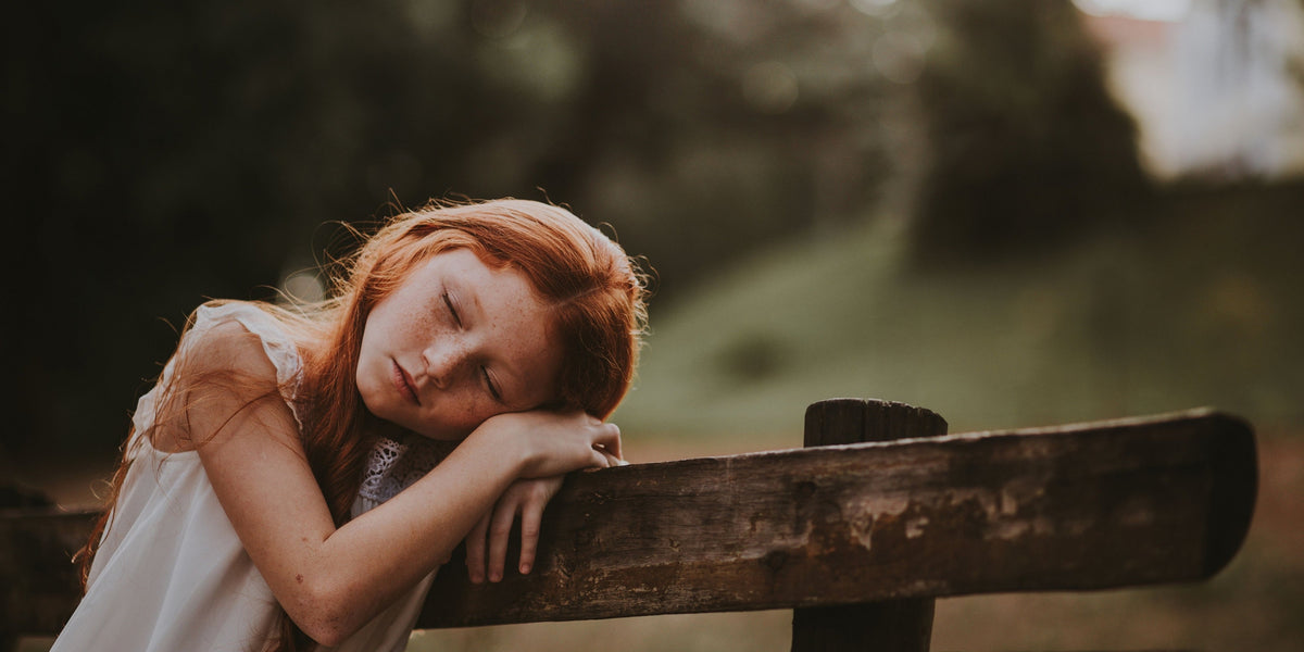 School-aged girl sleeping outside