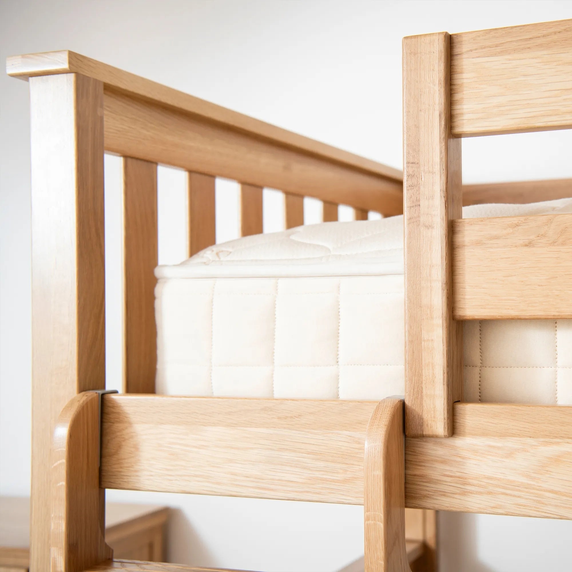 Wooden crib with white mattress against a plain background #size_twin/twin bunk