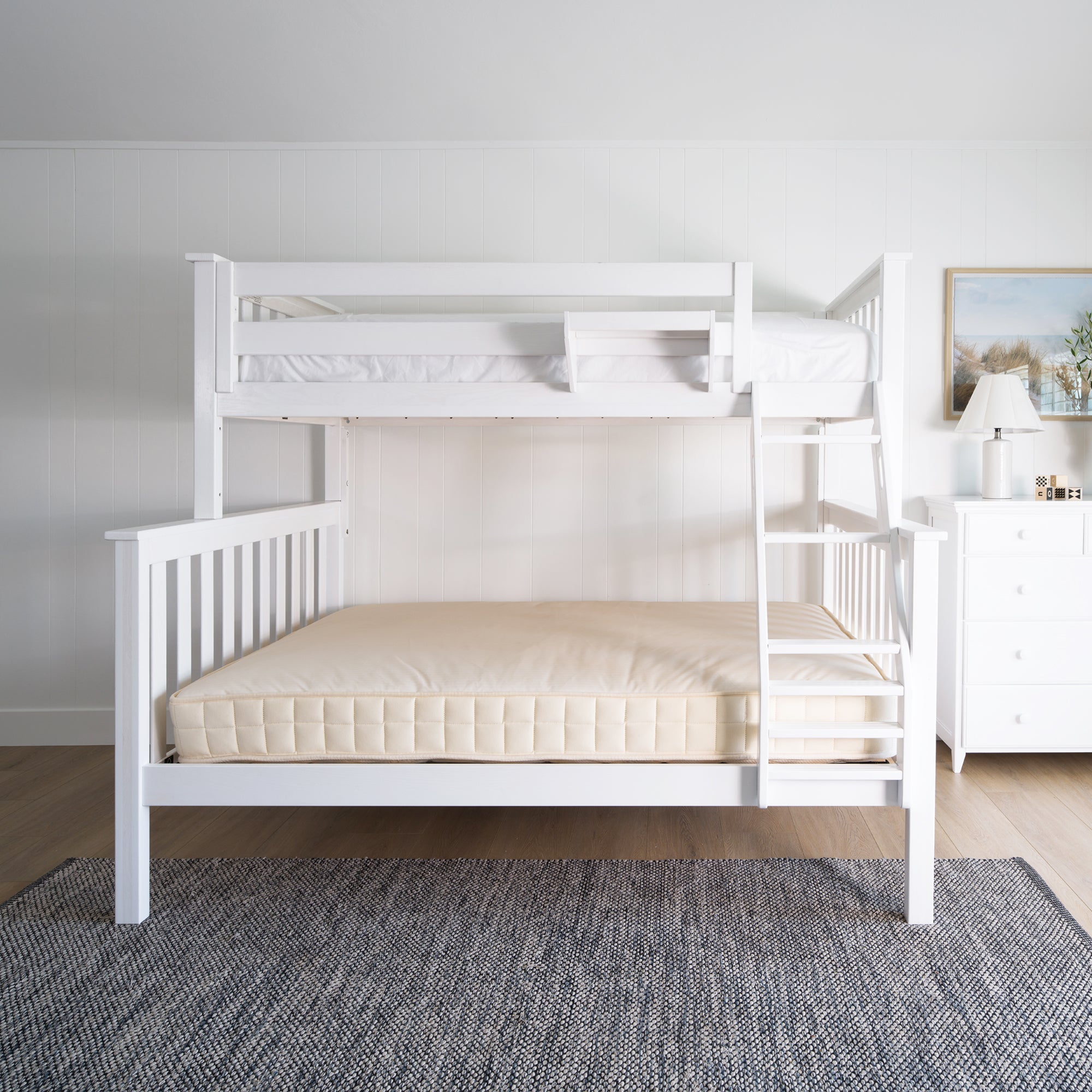 White bunk bed in a room with a gray rug and a dresser. #color_washed white  #size_Twin/Full Bunk 