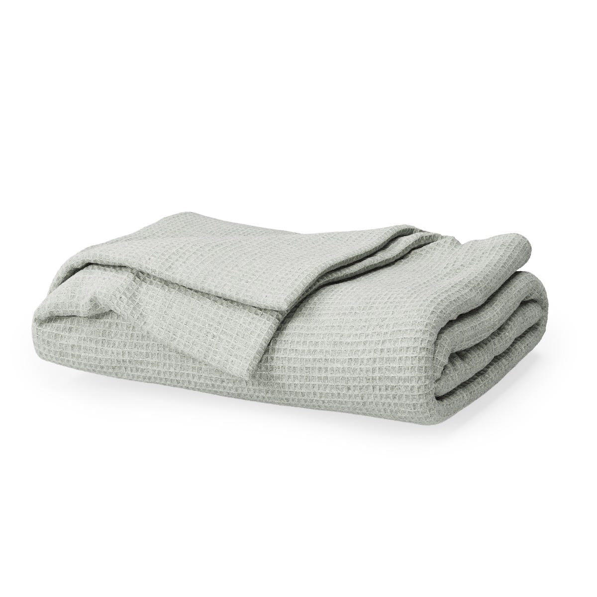 Folded light green blanket on a white background #color_sage